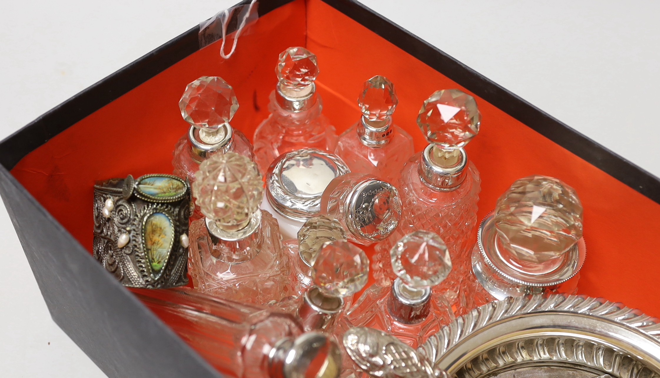 A collection of assorted silver mounted glass scent bottles and other items including a wine coaster etc.